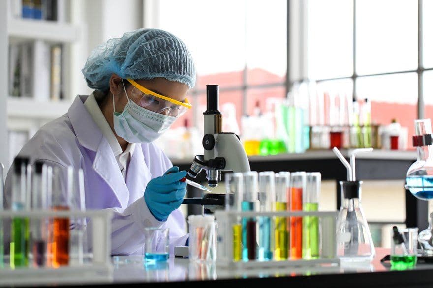 Lab technician examining a sample under a microscope